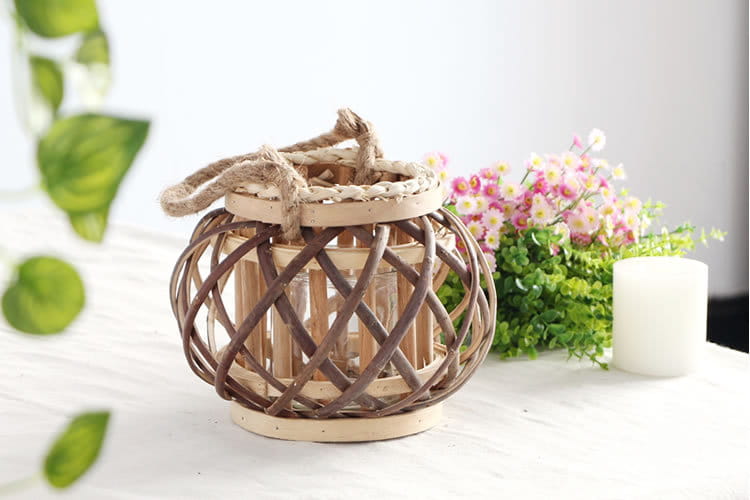 Un porte-bougie rustique en bambou tissé, avec un cadre en bois naturel, un intérieur en verre transparent et une poignée en corde tressée, conçu pour la décoration intérieure du domicile et l’usage des bougies, sans retour négatif.