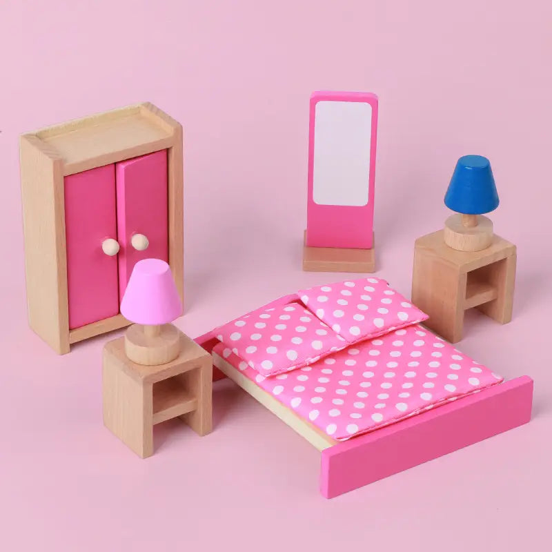 Rosa Holz-Puppenhaus-Bett mit weißer gepunkteter Bettwäsche als Teil eines Holz-Puppenhaus-Möbelsets für Kinder als Miniaturspielzeug.