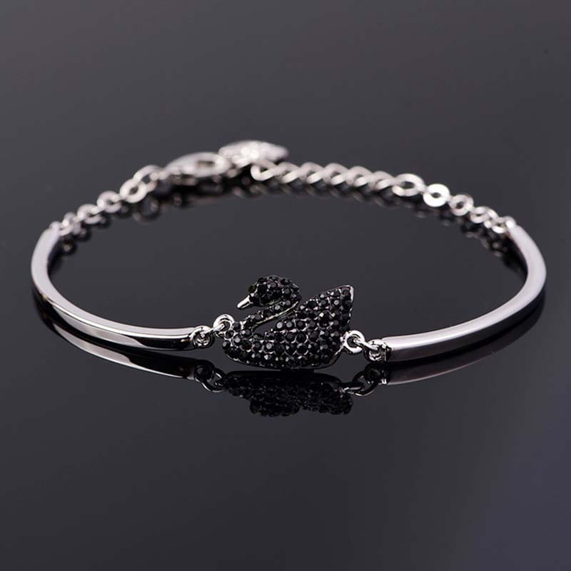 Bracelet jonc à tonalité argent, présentant une breloque de cygne sertie de cristaux noirs, pour une tenue élégante