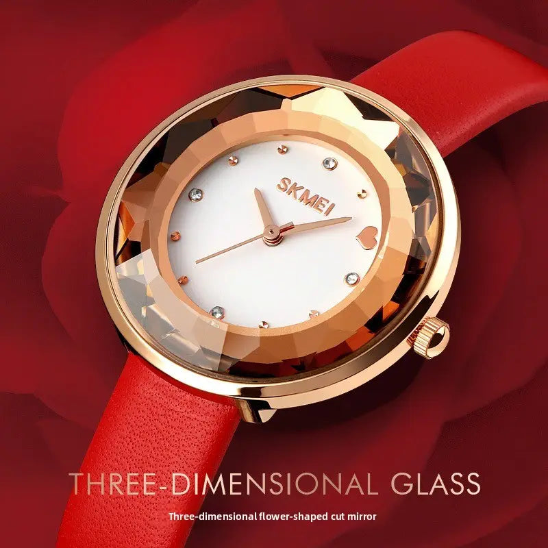 Rose gold-tone floral quartz watch with a white dial, diamond-like hour markers, heart-shaped accent at six o’clock, and a red leather strap in a gift box.