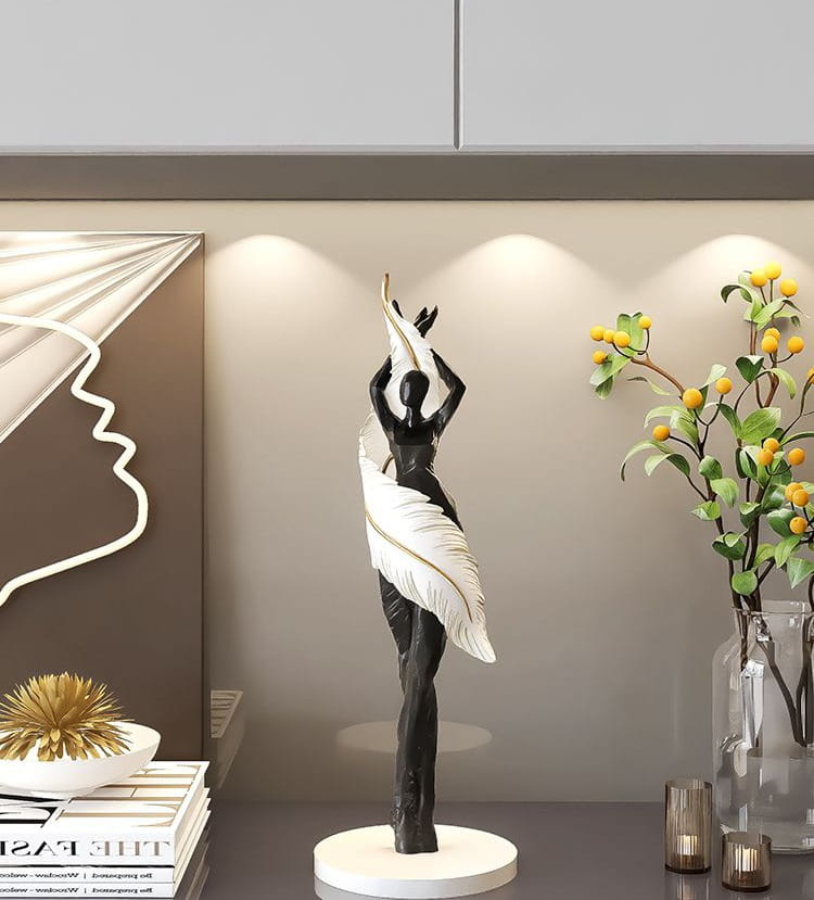 Figurine de danseuse en résine noir et blanc aux ailes déployées, debout sur une base circulaire mesurant 12x12x40 cm, parfaite pour une décoration intérieure moderne et des effets d'exposition.