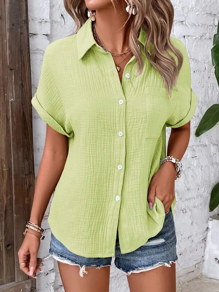 A light green women cotton short sleeve button up shirt with subtle textured fabric and white buttons.