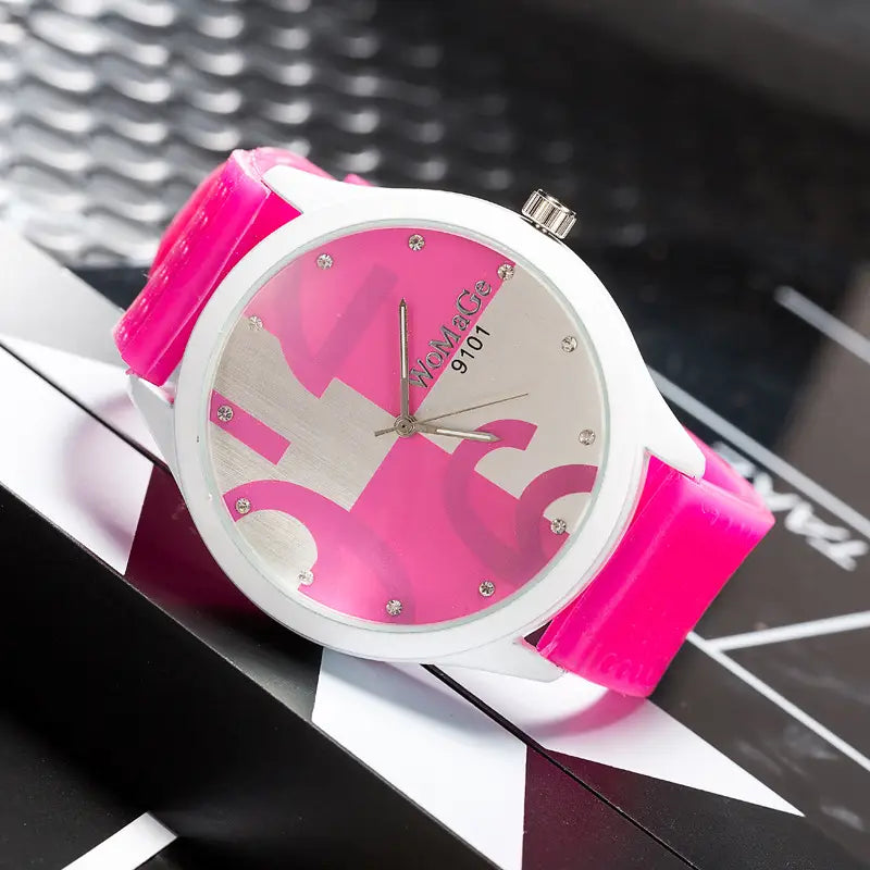A womage silicone quartz women sports watch with a vibrant pink and white glossy silicone strap and a bold abstract dial design accented by small rhinestones.