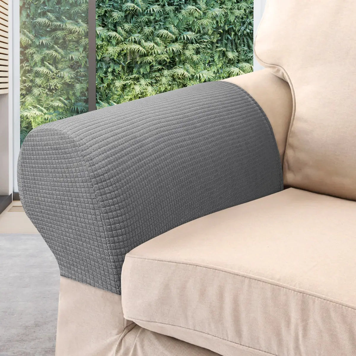 Graue strukturierte wasserabweisende Stretch-Abdeckung für die Armlehne aus Dunkelgrau-Spandex, die eng über die Armlehne eines beigen Sofas passt