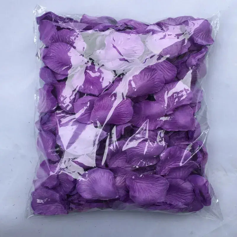 A bag of artificial purple rose petals made from soft satin-like material with delicate veining and slightly curled edges for colorful wedding decor.