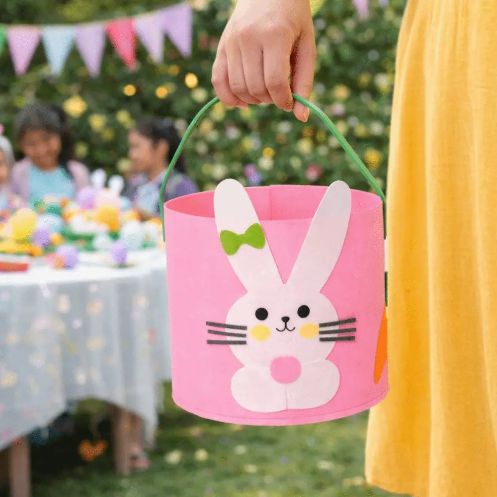 pink felt easter basket with a white bunny face featuring black eyes yellow cheeks and a green bow tie used as a yellow felt easter bunny basket gift bag