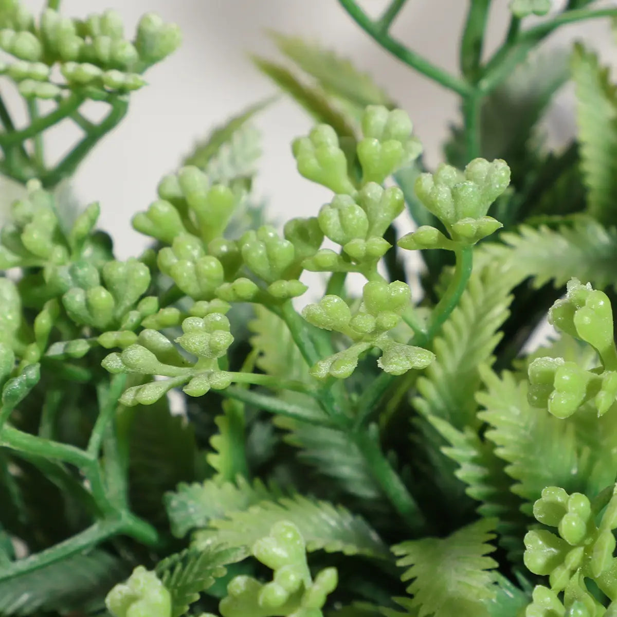 Artificial green fern plant with detailed textured leaves and small clustered buds in a small potted eucalyptus 17cm artificial plant ideal for indoor decoration.