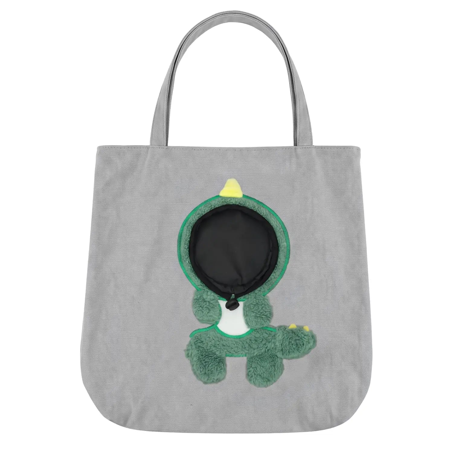 Sac de voyage en toile grise pour petits chiens, avec un dinosaure vert en peluche agrémenté d’accents jaunes et une poche intérieure noire, munie d’une boucle de sécurité pour un transport sûr de l’animal.