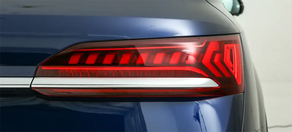 Vue arrière du couvre-carter de remplacement du feu arrière Audi Q7 2020-2024, montrant des bandes LED rouges élégantes et une barre d’accent chromée horizontale.