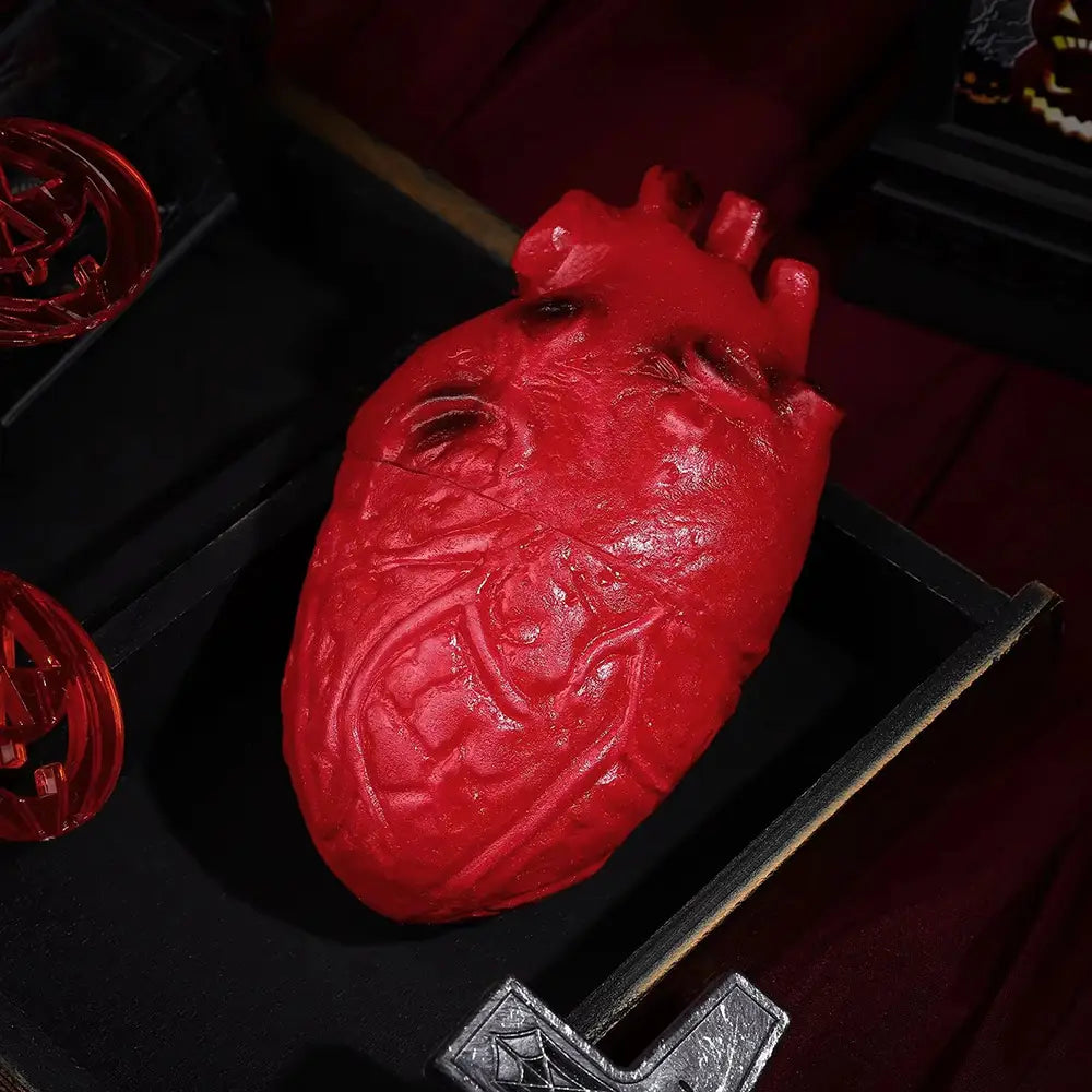 a glossy red fake bloody human heart halloween prop with an anatomically detailed textured surface and visible vein-like patterns