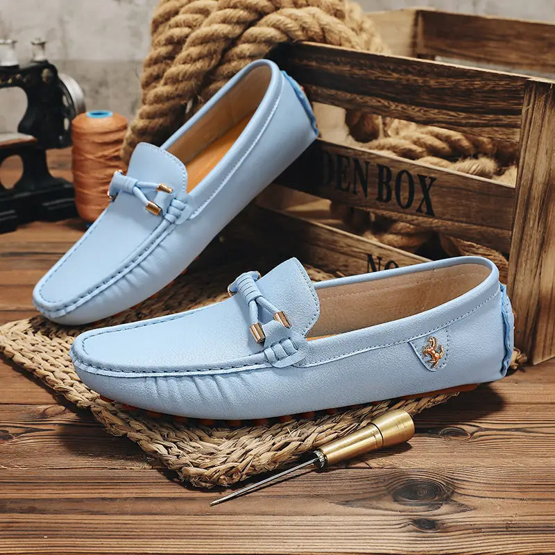 Chaussures à enfiler habillées en cuir bleu clair pour hommes, se portant sans effort avec des chaussures décontractées, avec des accents métalliques ton or et un petit logo de cheval brodé sur le côté.