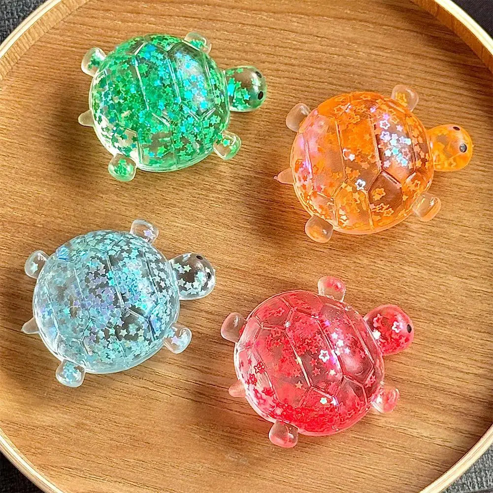 Vier farbenfrohe durchscheinende Harz-Schildkröten-Spielzeug-Fidget-Spielzeuge mit glitzernden Sternmustern, jeweils für Stresslinderung und weiches Knautschen in der Anwendung.