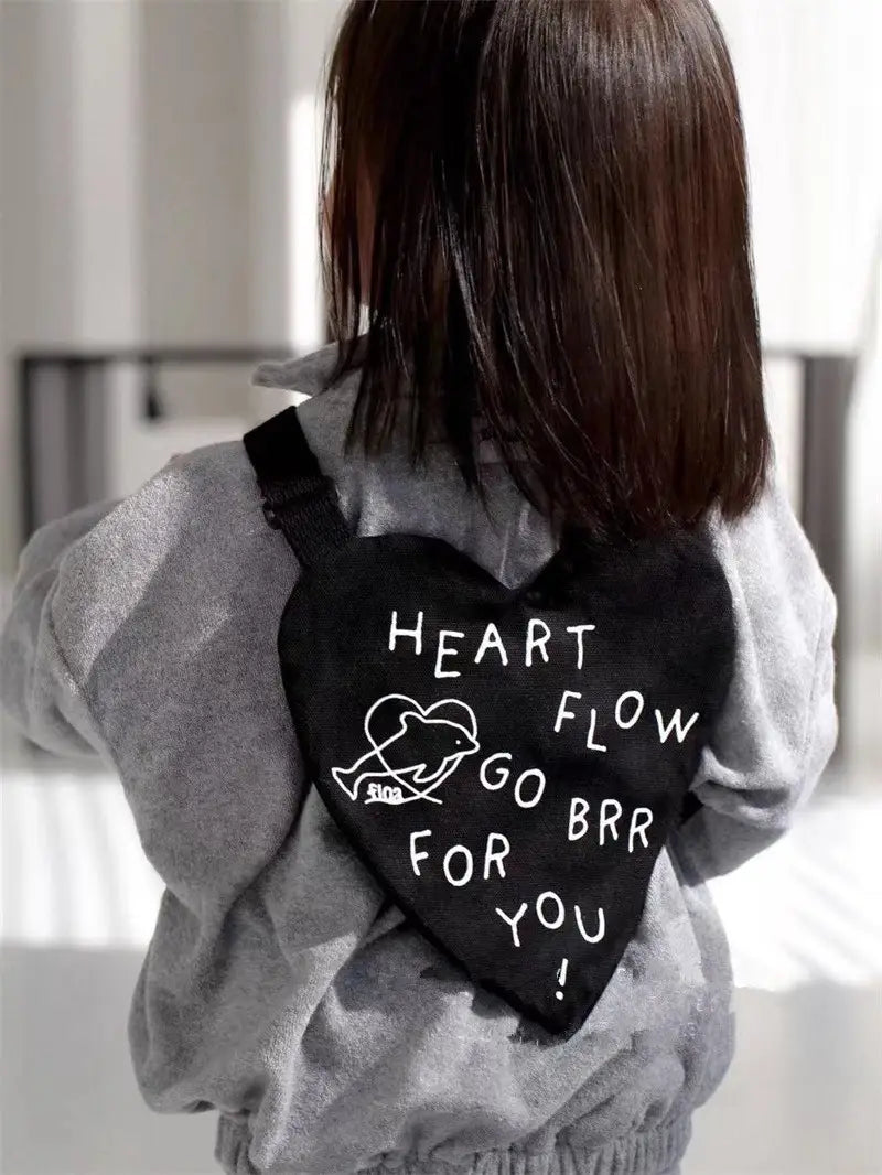 Schwarzer herzförmiger Umhänge-Rucksack für Kinder mit weiß besticktem Text und kleinem Wal-Design, ideal für den Alltag.