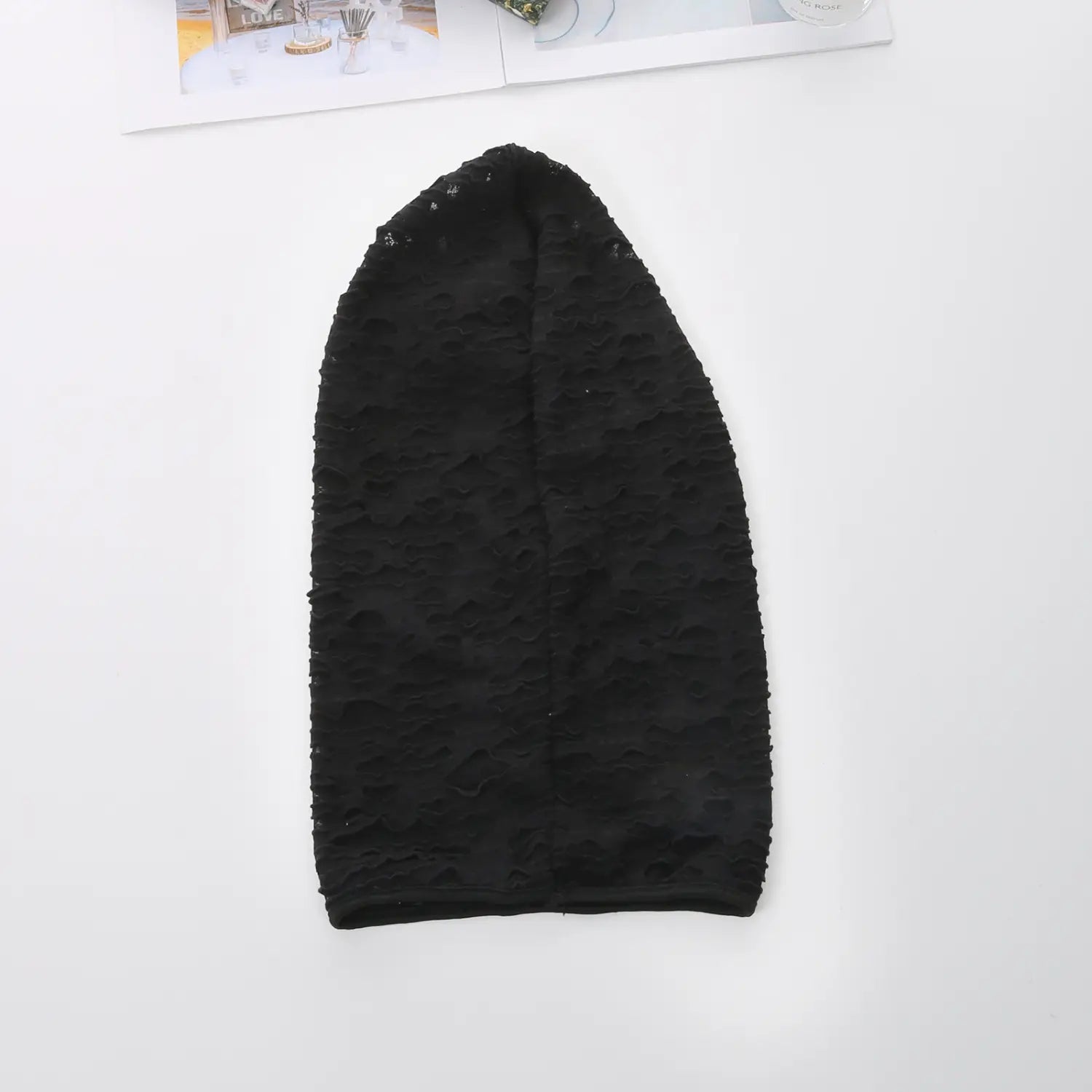 bonnet en tricot noir texturé avec un bord irrégulier légèrement effiloché, conçu comme une capuche en résille déchirée pour un cosplay de masque momie en résille déchirée.