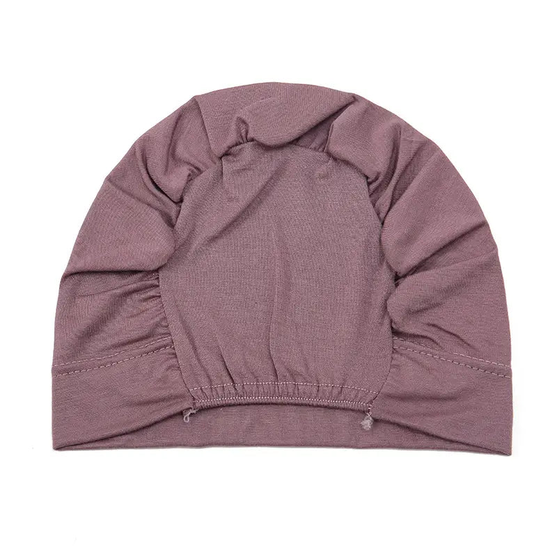 a soft mauve-colored stretchy jersey fabric hijab cap and turban set with a gathered crown and elasticated hem