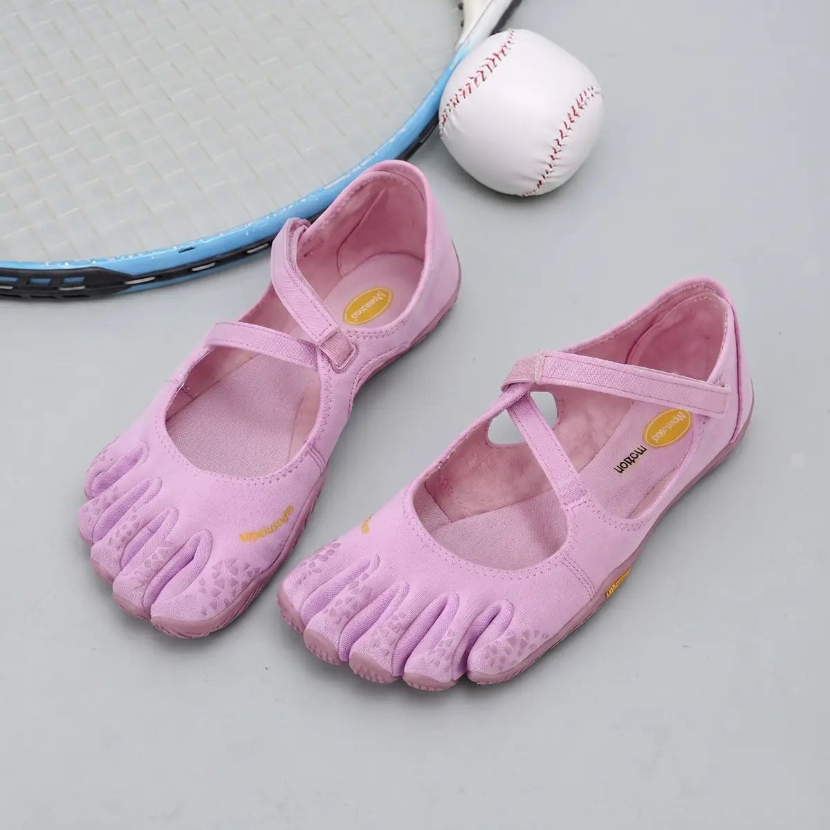 Women five toe minimalist barefoot shoes in pink with a soft suede-like upper, rubberized toe caps, and adjustable straps for a secure fit.