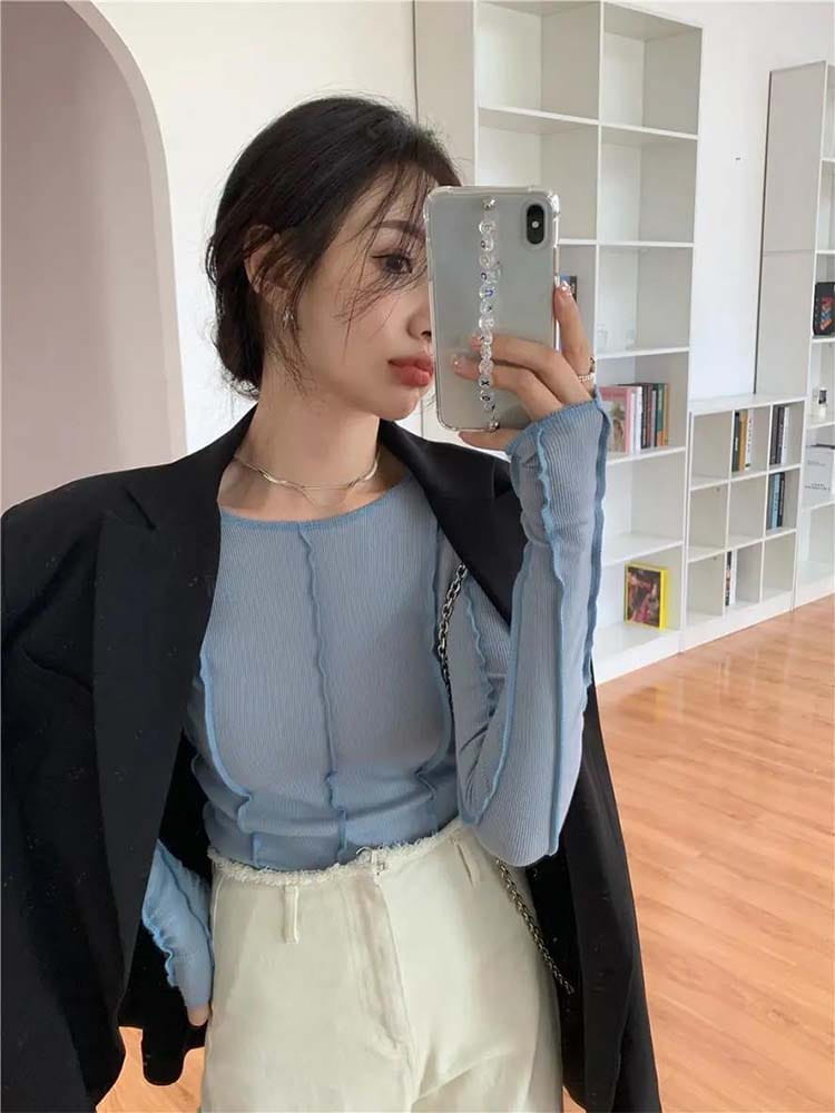 Silbernes Handyetui mit Kristallverzierungen, kombiniert mit einem hellblauen gerippten Longsleeve-Top für Damen mit schlankem Casual-Fit