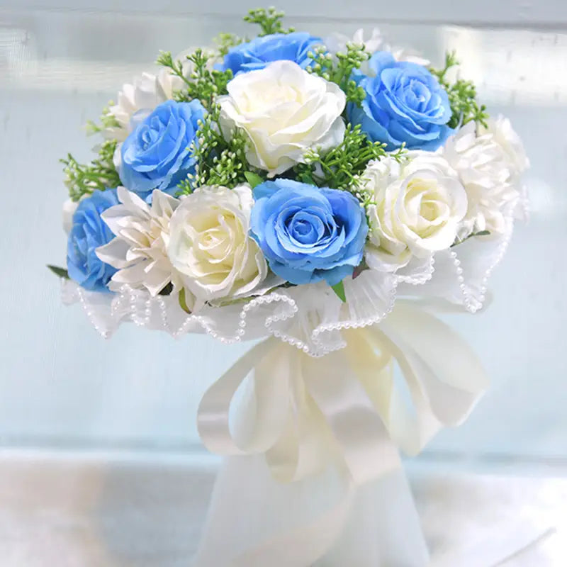Elegant white silk rose wedding bouquet featuring artificial blue and white roses with greenery, wrapped in lace and tied with an ivory satin bow.