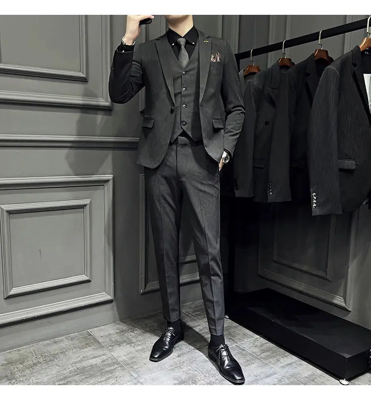 Ensemble de costume trois pièces slim fit noir, avec une texture subtile et un gilet assorti, comprenant 9 pantalons courts à la cheville et un type de fermeture par boutons.
