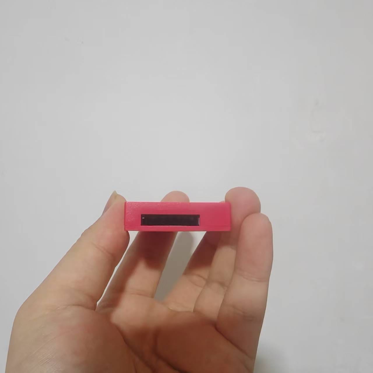 A compact vibrant pink game card storage box v2 accessory case with a black slot on its top surface.