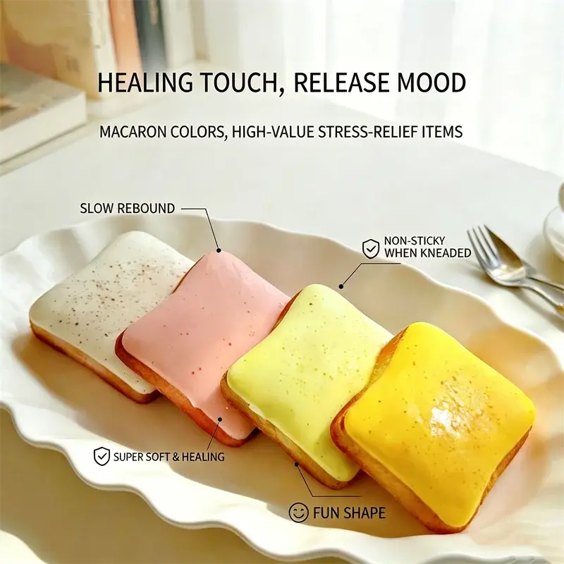 Quatre jouets anti-stress en forme de toast moelleux de forme carrée dans les couleurs macaron : blanc, rose, jaune et jaune doré, présentent une surface lisse et non collante pour un soulagement efficace du stress.