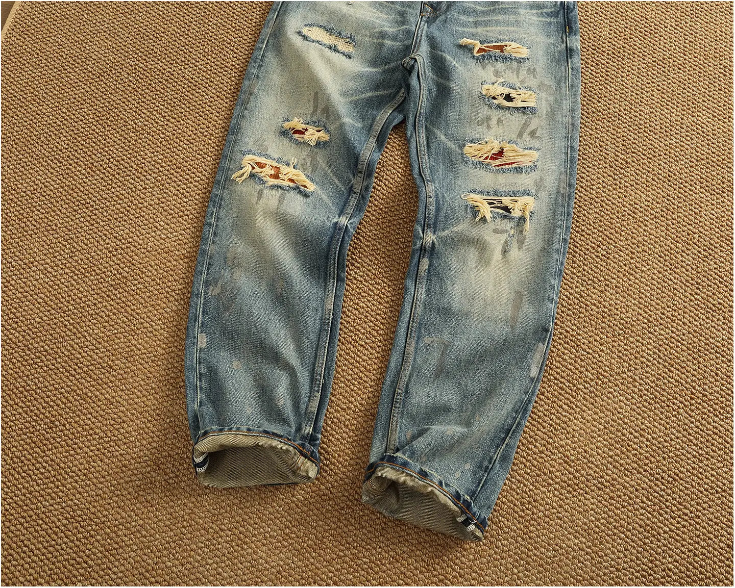 Light-wash distressed patchwork denim jeans for men featuring multiple rips and frayed edges.