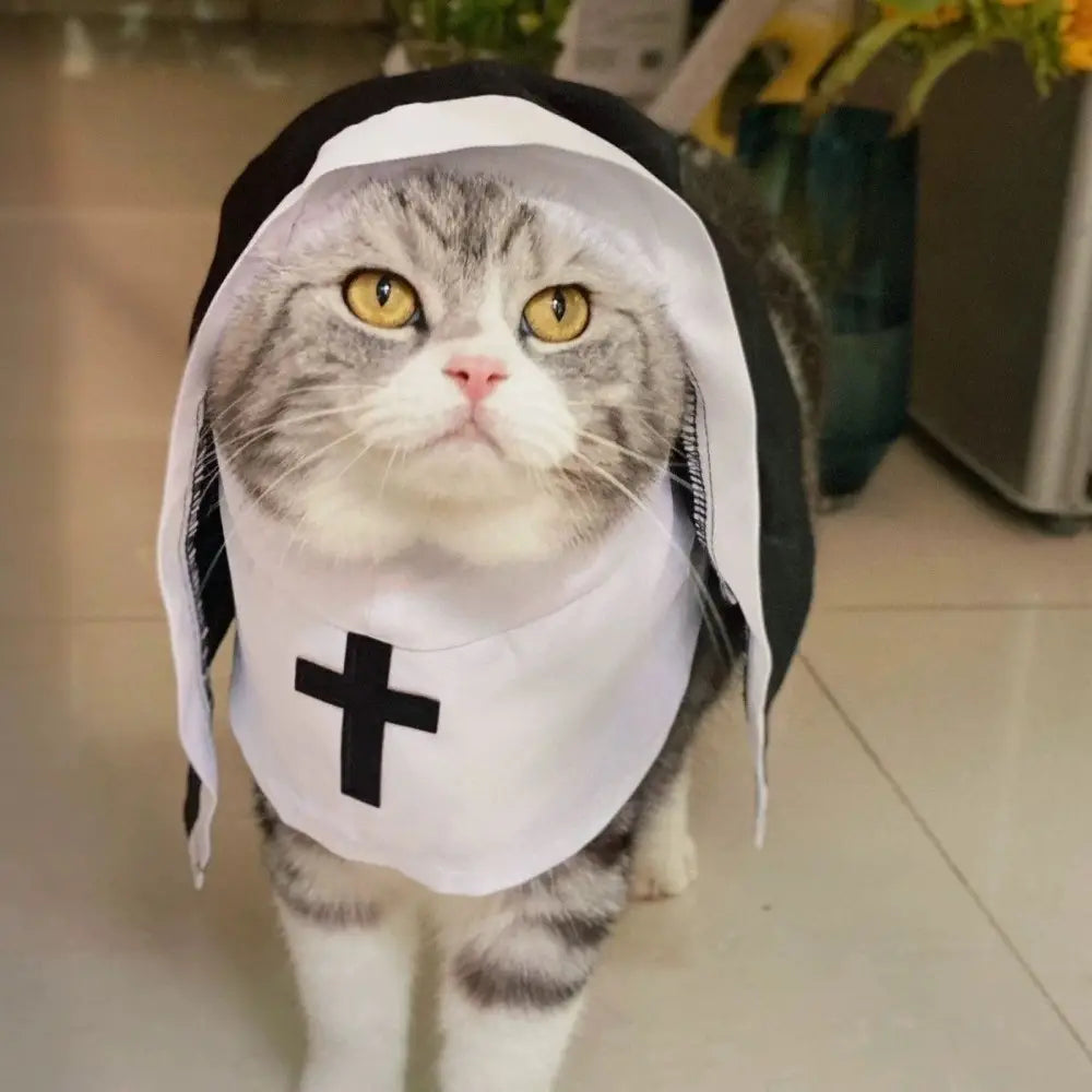 Gato atigrado gris con un disfraz de monja en blanco y negro hecho de fibra de poliéster, diseñado para uso de perro-gato mascota, con un emblema de cruz en la parte frontal.