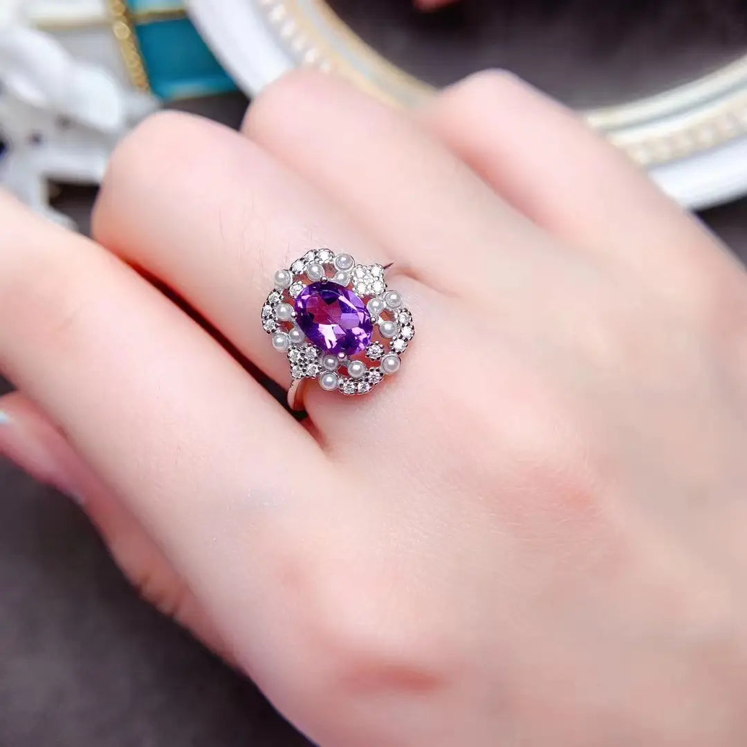 Une élégante bague en améthyste violette avec pierre ovale, entourée de diamants et d’accents de perles, montée sur un métal à tonalité argent de l’ensemble de bijoux en argent sterling avec quartz rose.
