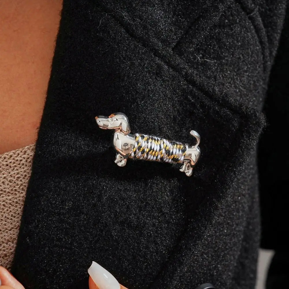 broche en teckel argentée présentant un corps tressé texturé avec des accents dorés et noirs, conçue comme broche à revers animalière.