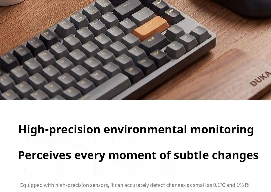 gray mechanical keyboard with one tan keycap resting on a wooden surface featured with duka mooda smart temperature and humidity clock for precise room monitoring