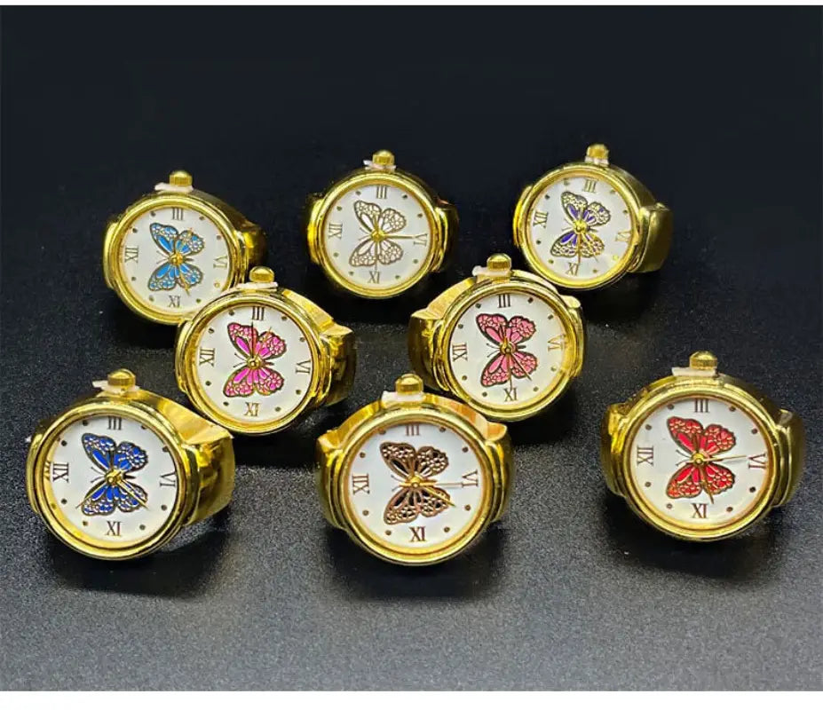 Gold-toned butterfly-themed ring watches with white faces roman numerals and stainless steel bands suitable as cute jewelry.