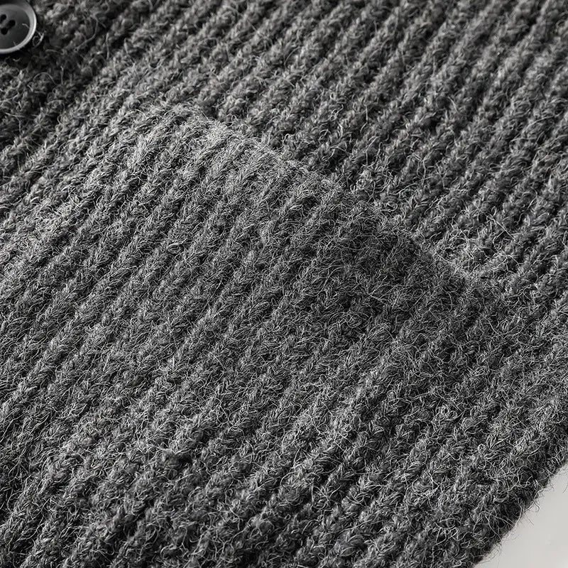 Dunkelgrauer strukturierter Strickstoff mit geripptem Muster und sichtbaren Garnfasern eines Herren-V-Ausschnitt-Strickcardigans