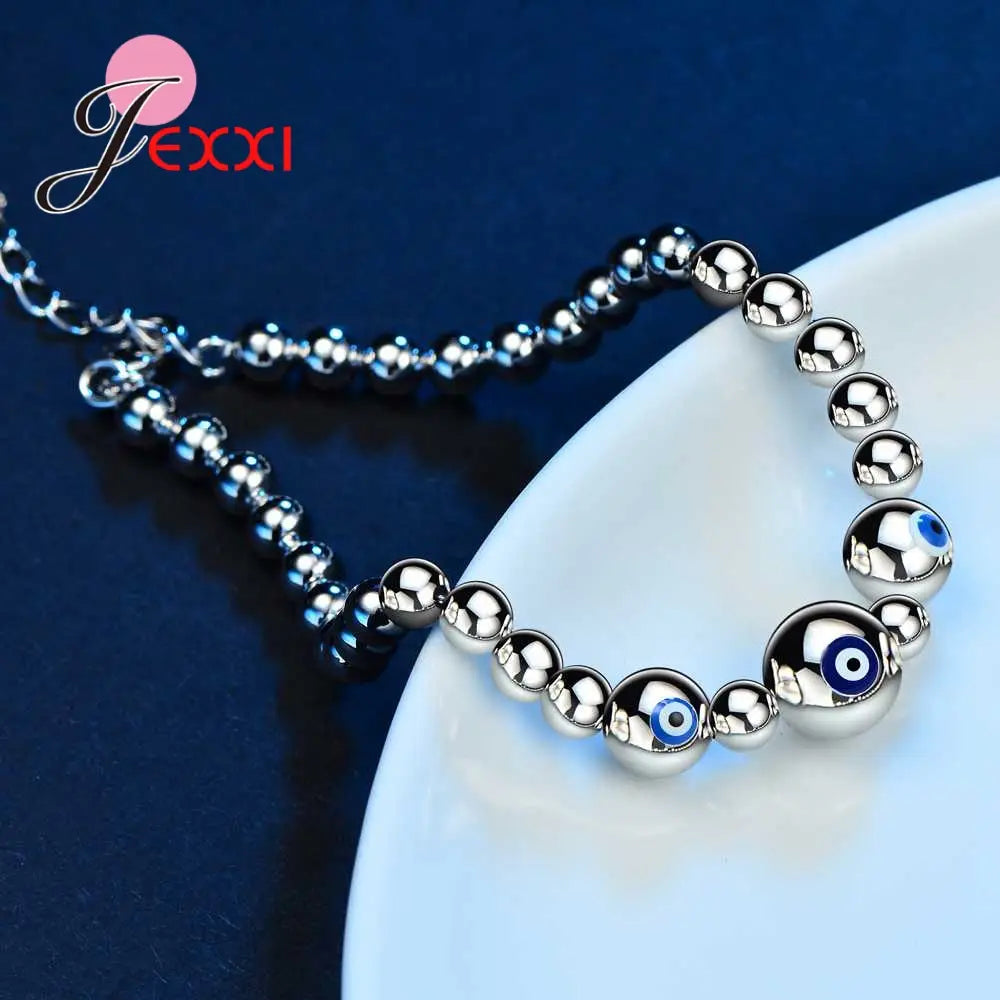 Sterling silver beaded bracelet for women featuring polished spherical beads and a central blue eye motif designed by jexxi.