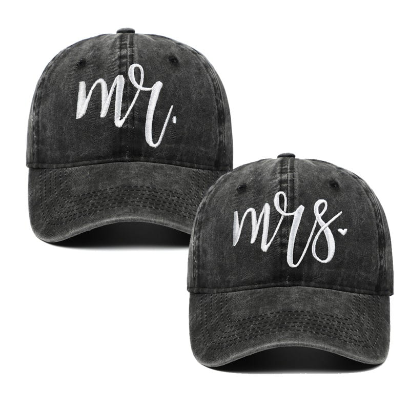 Une paire de casquettes de baseball en denim gris foncé délavées, avec broderie blanche « MR » et « MRS » en style script, agrémentée d’un petit cœur, conçue comme chapeaux parentaux.