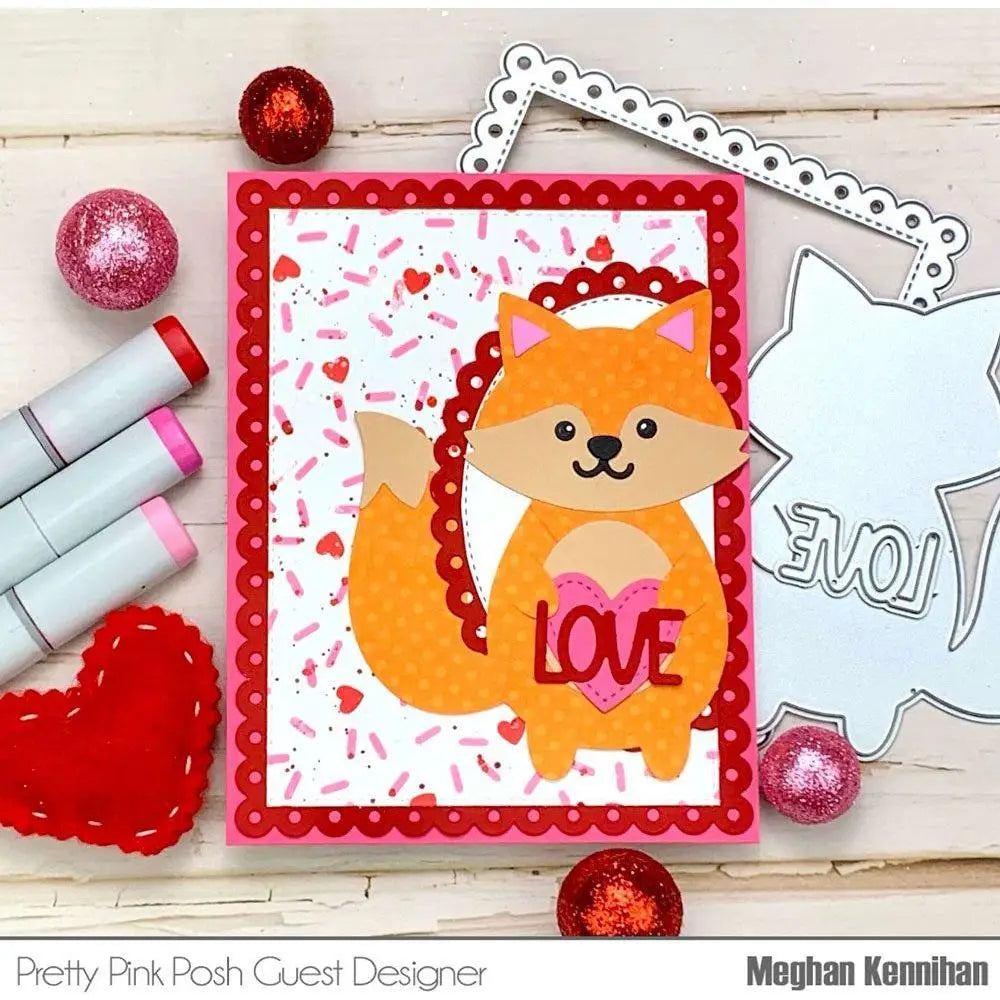 A cheerful orange fox-shaped valentine metal cutting die card with a pink heart that says love and red scalloped edges for valentine day crafting.