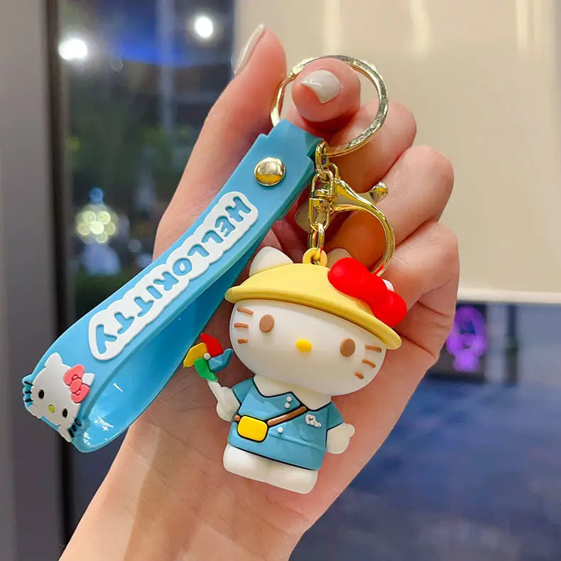 Blue hello kitty cartoon keychain featuring a white character with a yellow hat and blue outfit secured by gold-colored metal hardware for use as an anime bag charm.