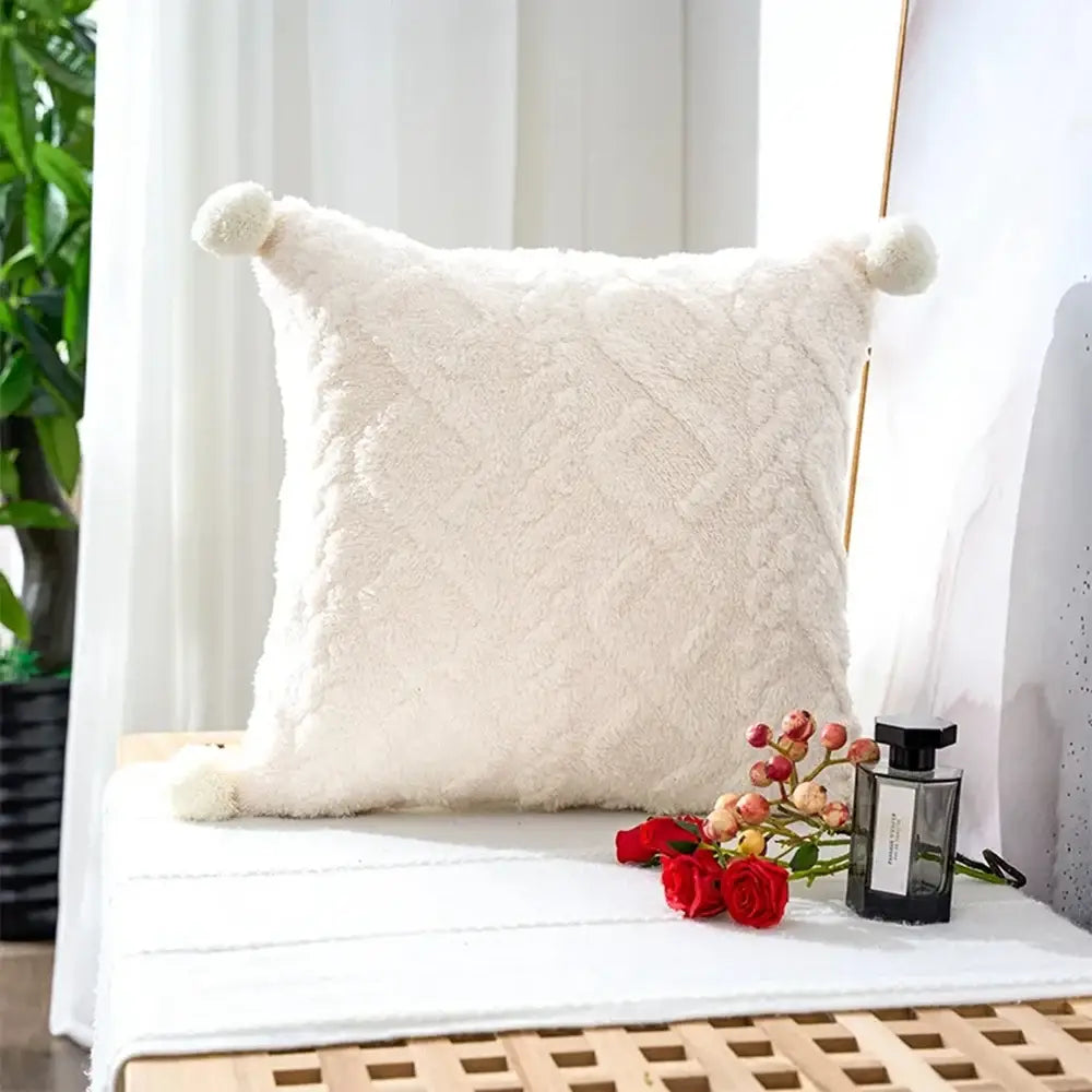Cream-colored plush geometric throw pillow cover with a diamond-quilted pattern and soft pom-pom accents on each corner sized 45x45cm.