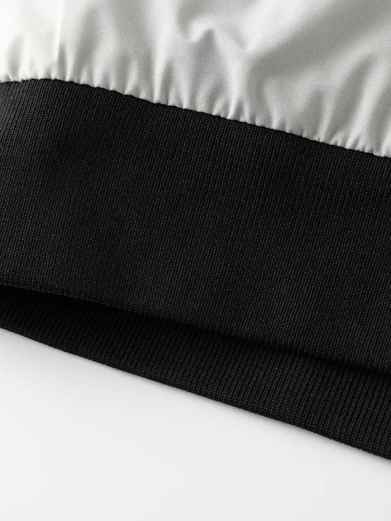 black ribbed knit cuff with contrasting white satin panel on a waterproof hiking jacket men windbreaker designed for autumn hiking
