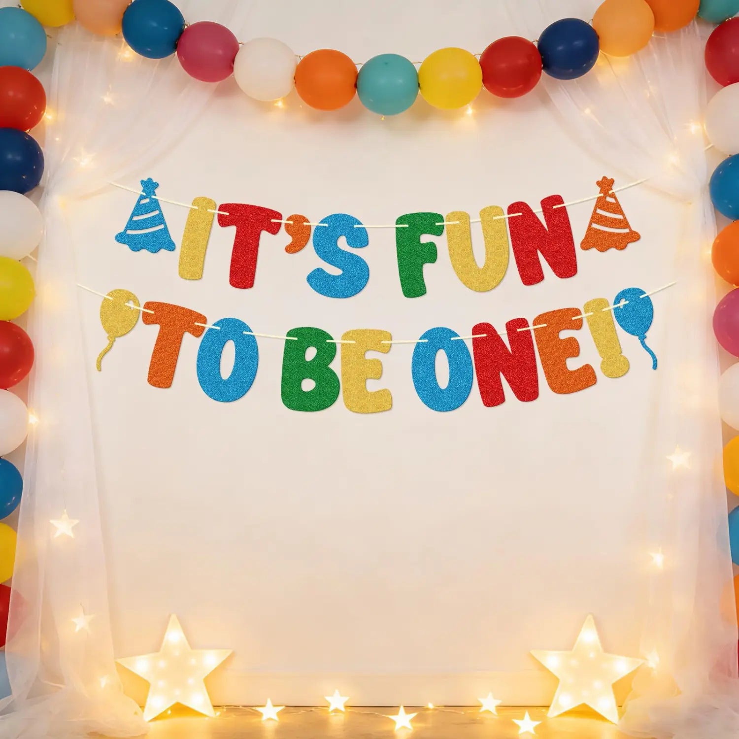 Ein farbenfrohes glitzerndes Banner zum ersten Geburtstag mit der Aufschrift „Es macht Spaß, eins zu sein“ in kräftigen mehrfarbigen Buchstaben, mit festlichen Partyhütchen- und Ballon-Ausschnitten zur Partyd...