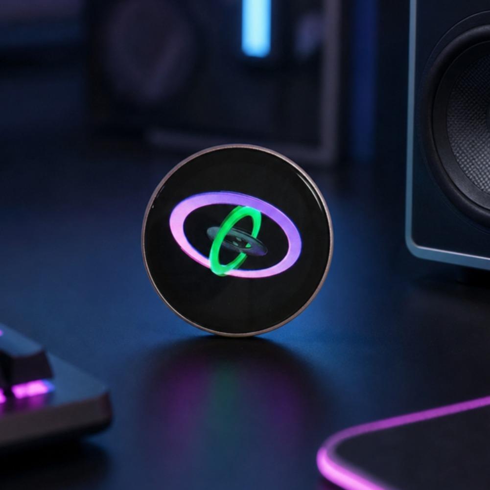 A sleek black mini gadget smart desktop companion with a metallic rim and a glowing green and purple ring design, accompanied by a data cable.