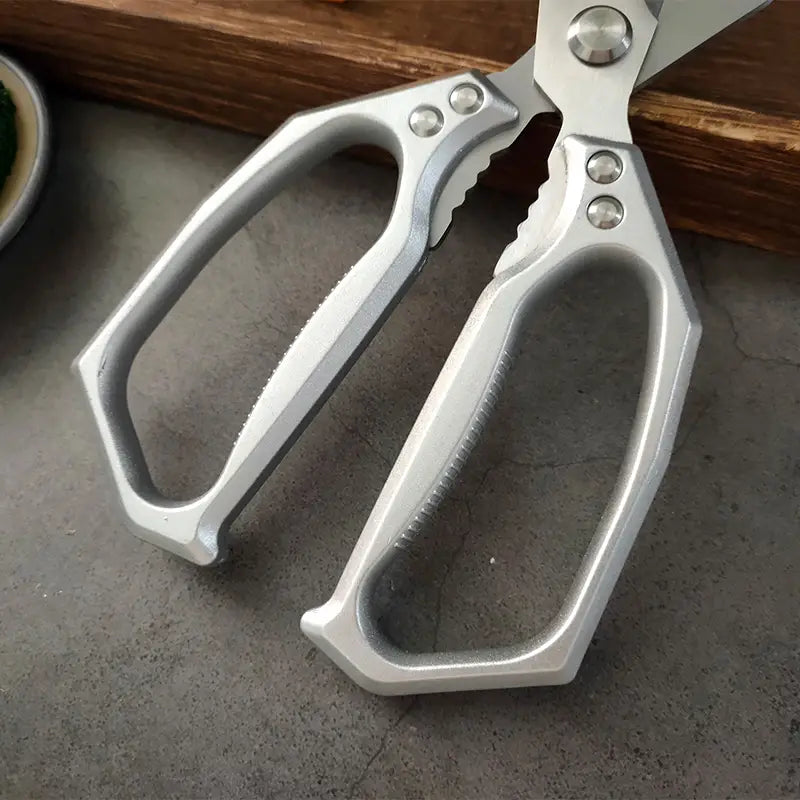 Silberfarbene Edelstahl-Multifunktionsküchenscheren mit ergonomisch strukturierten Griffen und stabiler Metallkonstruktion.