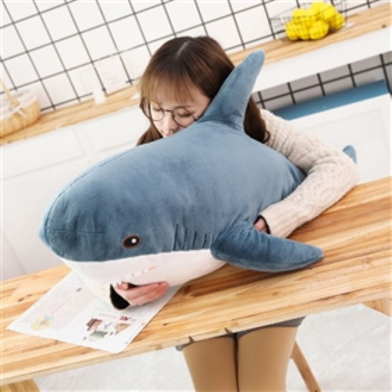 plush blue shark stuffed animal pillow featuring blue and white soft fabric with black embroidered eyes.