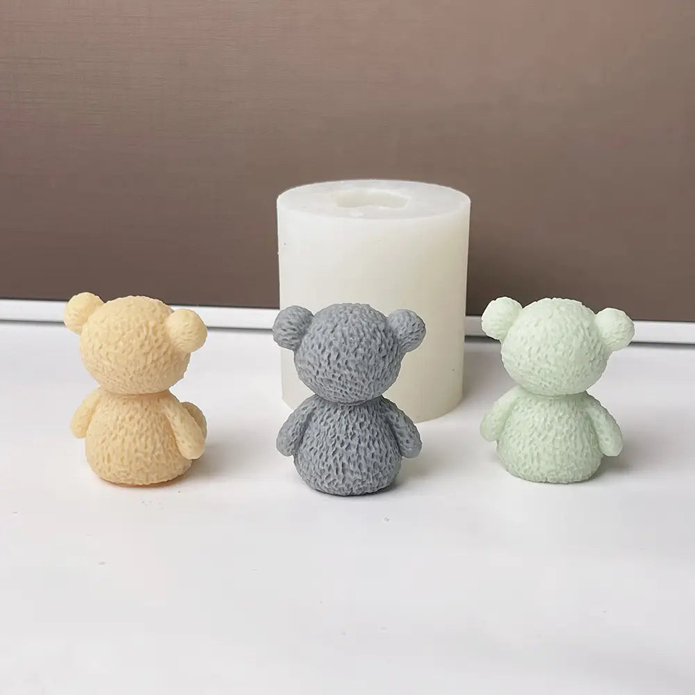 drei Miniatur-Bär-förmige Silikonformen in beige-grau und mintgrün für die Herstellung von Mini-Teddybär-Kerzen.