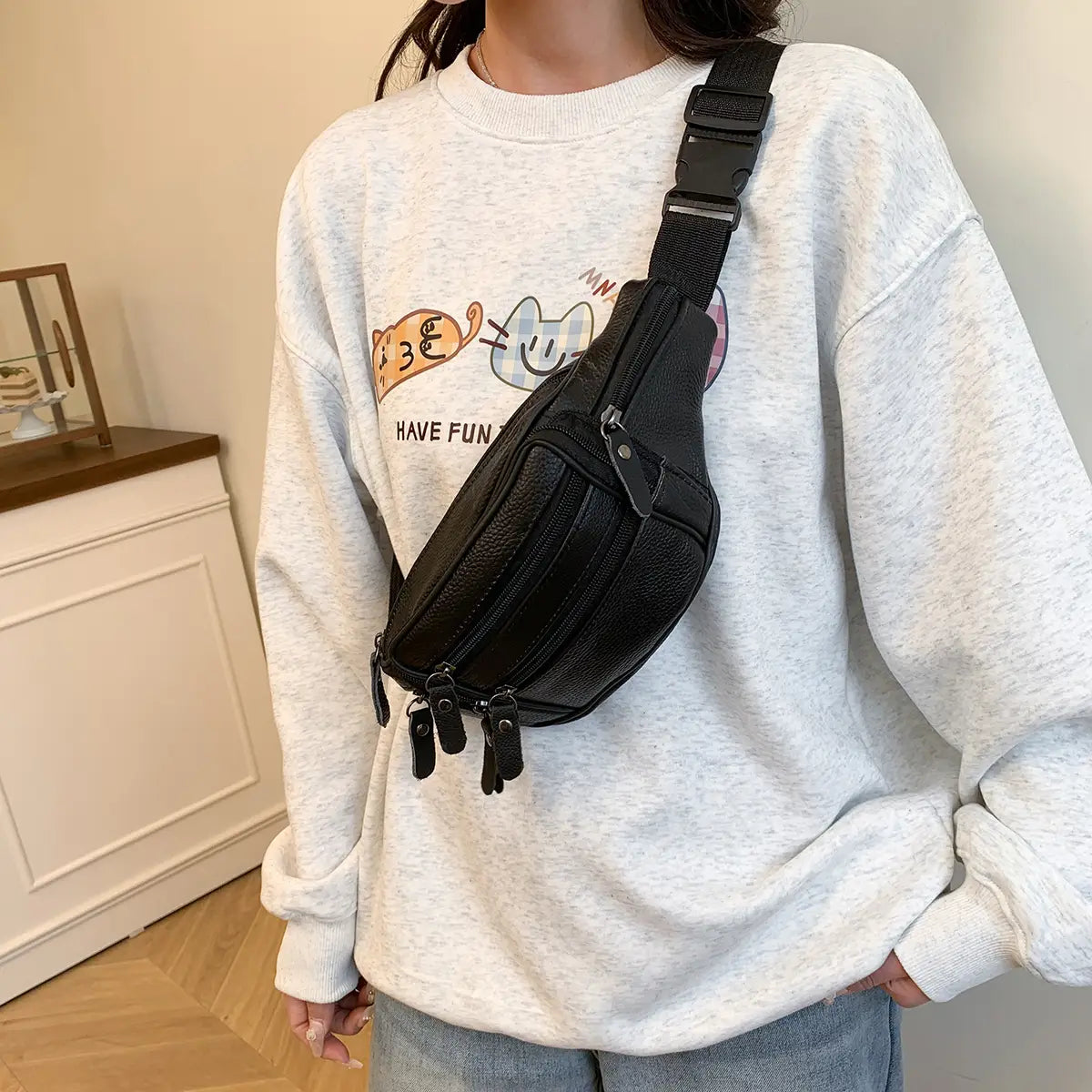 Schwarze Gürteltasche aus echtem Leder mit strukturierter Oberfläche, mehreren Reißverschlüssen und verstellbarem Riemen für die Verwendung als Crossbody- oder Bauchtasche