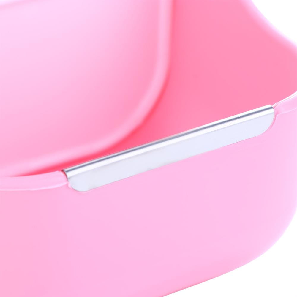Pink plastic rabbit hay feeder with silver metal handle and attached food bowl for small animals.