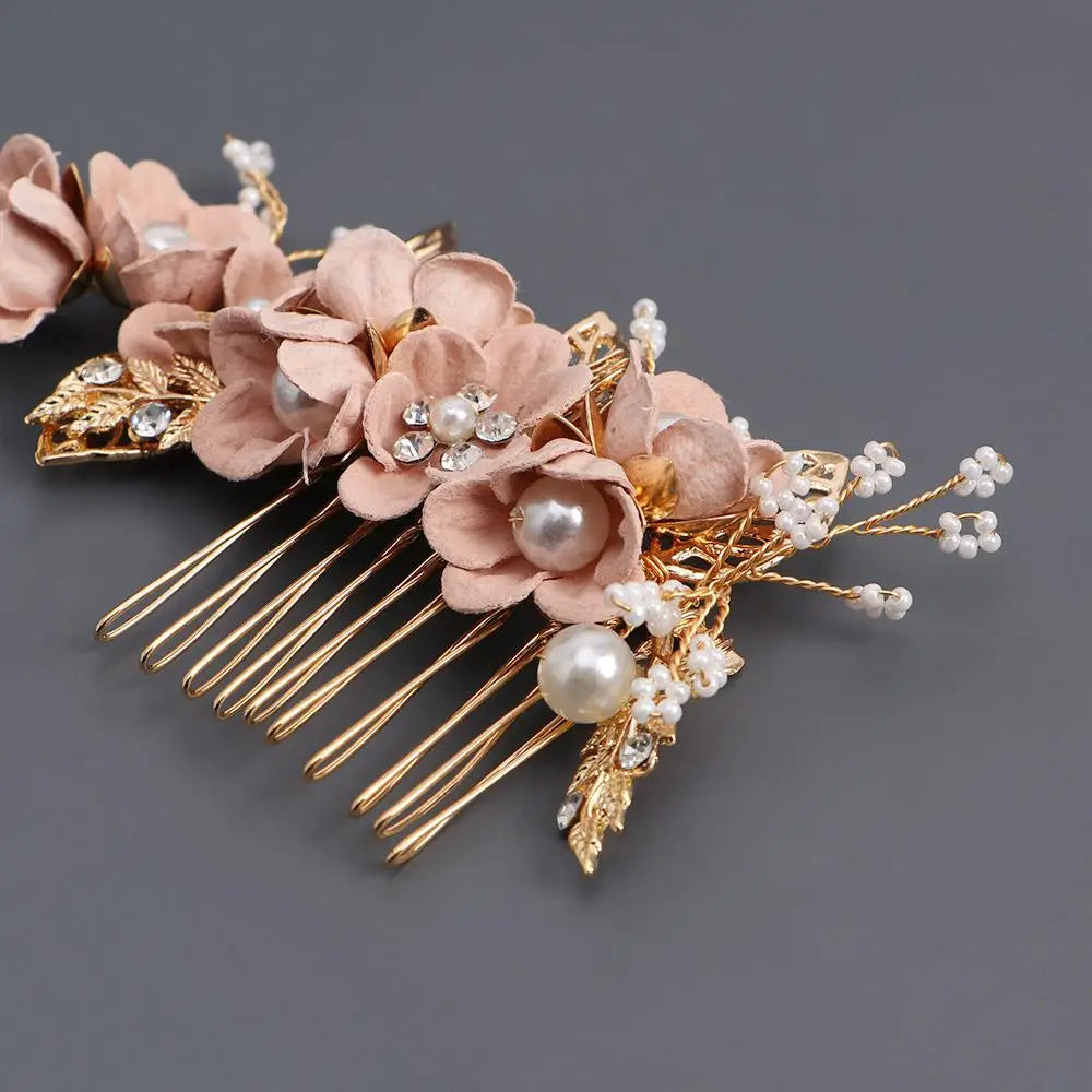 結婚式のヘッドピース用として、ブラッシュピンクのファブリックフラワー、パールのアクセント、きらめくクリスタルのディテールを取り入れた、繊細なゴールドトーンのフローラル・ブライダル用ヘアコーム。