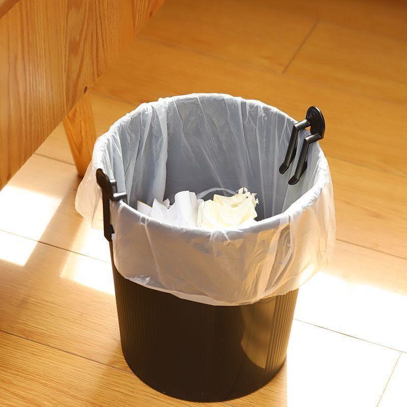 Poubelle en plastique noir avec des attaches de sacs-poubelle en plastique durable, à fixation par clips noirs, assurant la tenue d’une doublure en plastique transparent.