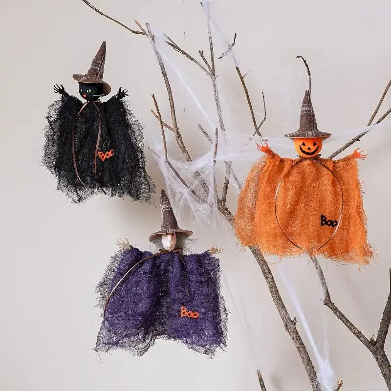 tres adornos de halloween de bruja con colgantes colgantes hechos de capas de tela con textura en negro, naranja y morado, con sombreros puntiagudos a juego y parches bordados de boo