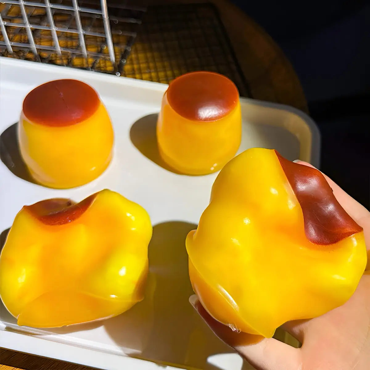 Glossy yellow and amber-colored gelatin peach shaped pudding squishy ASMR stress relief toy designed for tactile relaxation.