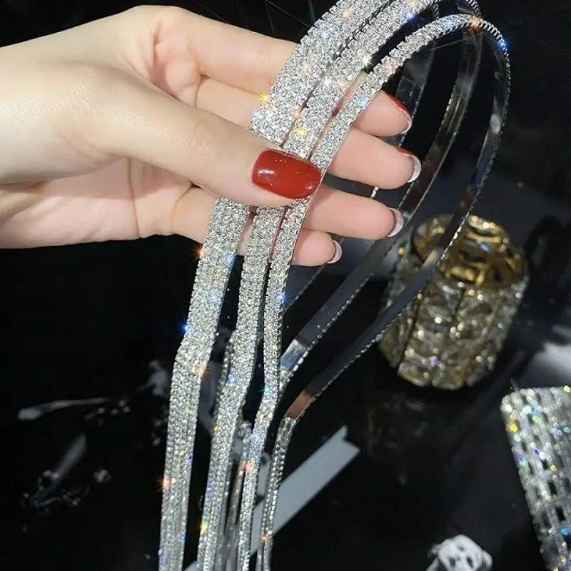 A sparkling silver crystal rhinestone tassel headband for women featuring a sleek curved design with densely embedded crystals.